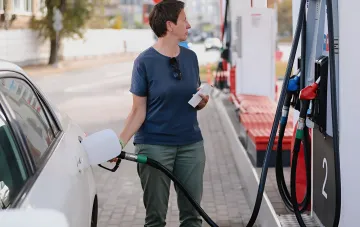 Tanken an einer Tankstelle in Kiew: Kunde mit Beleg an der Zapfsäule vor dem Hintergrund eines stabilen Kraftstoffmarkts