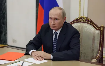 Владимир Путин за рабочим столом во время визита во Владивосток, где его кортеж сопровождал пикап с зенитным пулемётом
