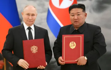 Подписание документов между Россией и КНДР: обмен красными папками с гербами на фоне флагов двух стран, иллюстрирующее военное сотрудничество, нарушающее резолюции Совбеза ООН