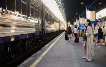 Passagiere mit Gepäck warten auf einen Zug am Bahnsteig während der Verspätungen der ukrainischen Eisenbahn (UZ)