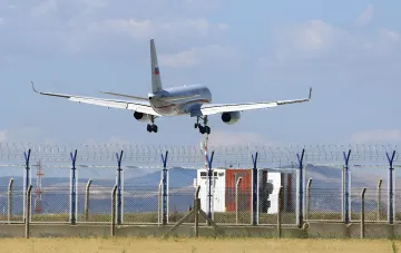 Гражданский пассажирский самолёт российского перевозчика с выпущенным шасси на фоне аэропортового ограждения — иллюстрация угроз для авиации после закрытия неба РФ