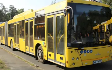 Gelber Gelenkbus in Kiew auf der temporären Linie 1-M über die Metro-Brücke