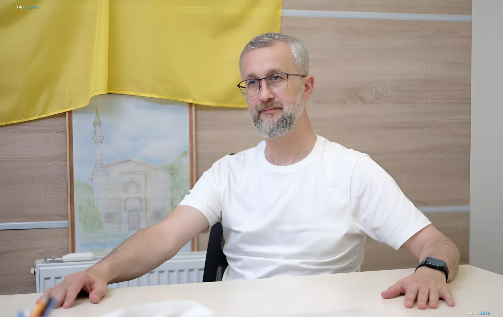 Посол Украины в Турции за столом на фоне украинского флага и картины с мечетью, комментируя реакцию Анкары на заморозку переговоров
