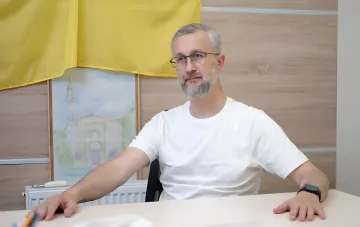 Посол Украины в Турции за столом на фоне украинского флага и картины с мечетью, комментируя реакцию Анкары на заморозку переговоров