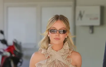 Sydney Sweeney in Venedig in einem vintage Spitzen-Top in Creme mit Rüschen und schmalen dunklen Sonnenbrillen