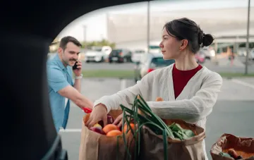 Украинцы запасаются продуктами: пара загружает овощи и фрукты в багажник автомобиля, следуя рекомендации держать недельный запас