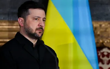 Владимир Зеленский на фоне украинского флага во время заявления об эскалации после атаки на 13 областей Украины