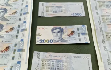 Ukrainian 2000 hryvnia banknotes in circulation: new denomination notes with a portrait and a building shown on a table