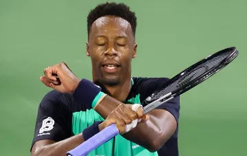 Гаэль Монфис в момент прощального матча на US Open, держит ракетку и вытирает пот