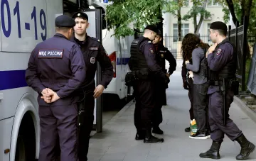 Beamte des russischen Innenministeriums (MWD) neben einem Dienstfahrzeug: Illustration zum Bericht über den Tod eines Obersten, der das Anti-Extremismus-Zentrum in Jekaterinburg leitete