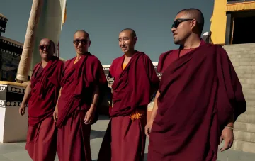 Buddhistische Mönche in bordeauxfarbenen Roben vor einem Kloster in Ladakh — ein Bild aus der Kampagne «Meditation in Motion» von PUMA India
