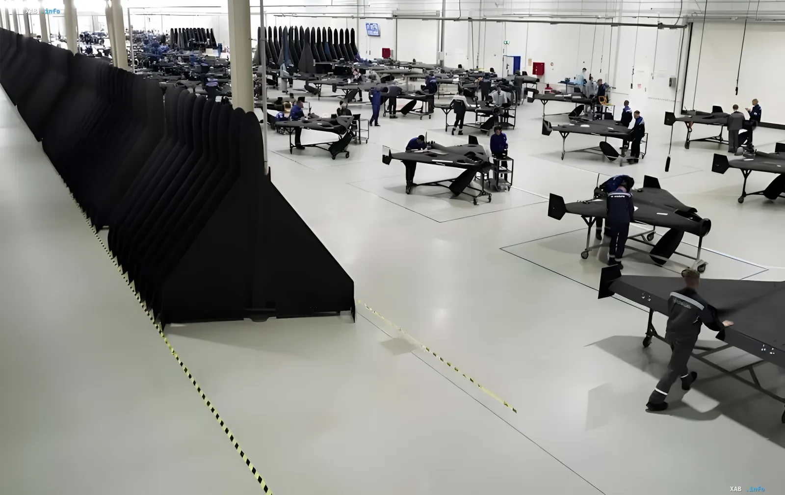 Conveyor assembly of Geran kamikaze drones at a Russian plant: workers at workbenches and rows of wings preparing the release of about 2000 jet-powered units