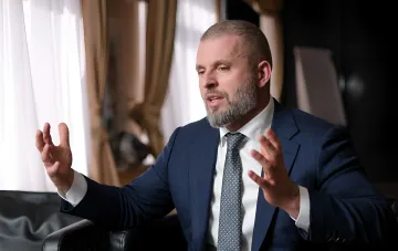 Football official in a business suit gesturing during an interview about Ukraine and Poland co-hosting the FIFA World Cup