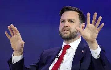 Джодж Вэнс жестами объясняет позицию США по Ирану на фоне синего задника