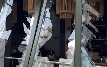 Shattered windows and storefront of the Zaver tailo bakery on Podil, Kyiv, after the destruction: glass shards hanging on the frame