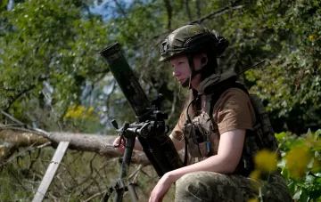 Ukrainian female soldier with a mortar on the front line during combat operations