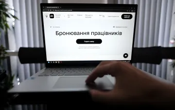 Человек использует ноутбук для подачи заявления на бронирование работников на портале «Дія»