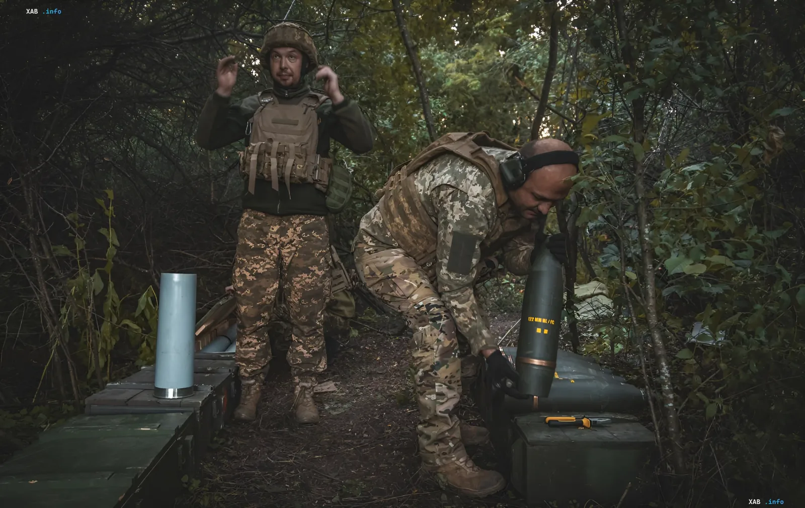 Ukrainian soldiers prepare 122 mm artillery shells at a forest position during the defensive operation