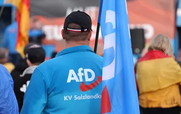 Сторонник AfD в куртке с логотипом партии на предвыборном мероприятии в Саксонии-Ангальт, где AfD набирает 44,2%