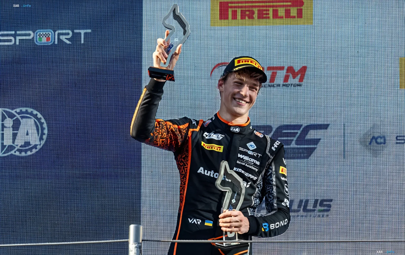 17-year-old Ukrainian driver Bondarev in Williams Driver Academy suit lifts trophies on the podium after winning the Formula Regional European Championship