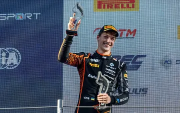 17-летний украинский гонщик Бондарев в форме Williams Driver Academy поднимает трофеи на пьедестале после победы в Региональной Формуле Европы