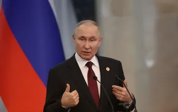 Владимир Путин выступает с речью на фоне российского флага в контексте гибридных угроз, против которых Германия готовит комплекс мер