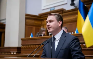 Кравченко выступает у микрофона в зале с украинскими флагами, опровергая причастность к операции «Карфаген»