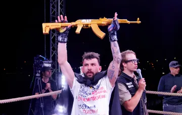 Боец поднимает золотой АК-47 с логотипом M13 FIGHTS на шестом турнире военных в Киеве
