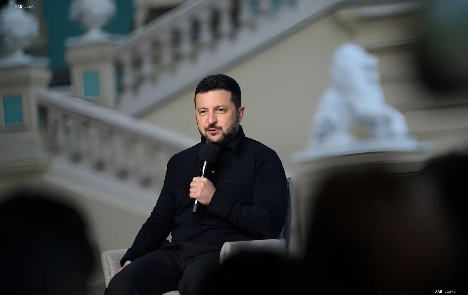 Volodymyr Zelensky holding a microphone against a staircase and sculptures, commenting on substantive and productive talks with US special representatives