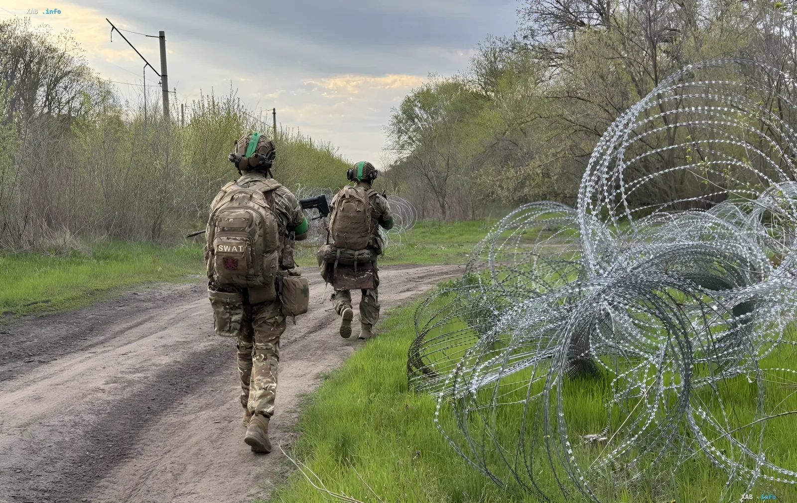Бойцы 225-го штурмового полка 7-го корпуса ДШВ идут по дорожке вдоль колючей проволоки на передовой