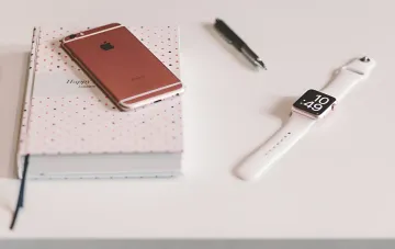 Розовый iPhone и Apple Watch на белом фоне — примеры устройств Apple, снятых с продаж и поддержки в 2026 году