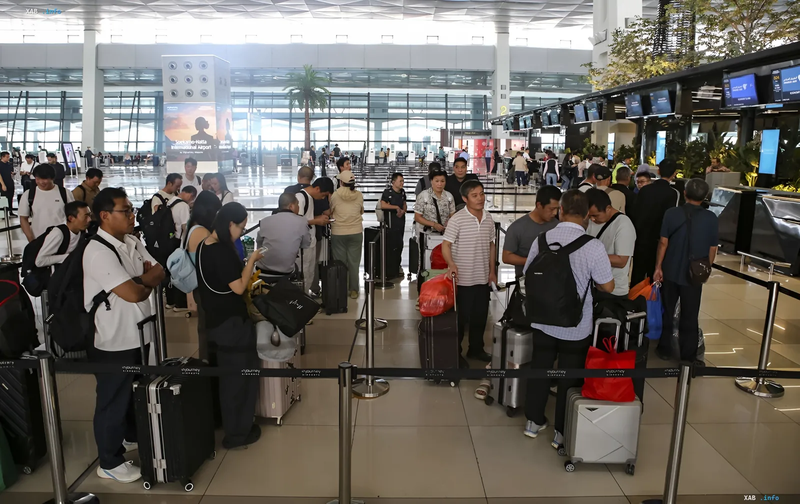 Passengers with luggage queue at Soekarno-Hatta Airport in Jakarta amid flight cancellations due to Anak Krakatau volcanic eruption