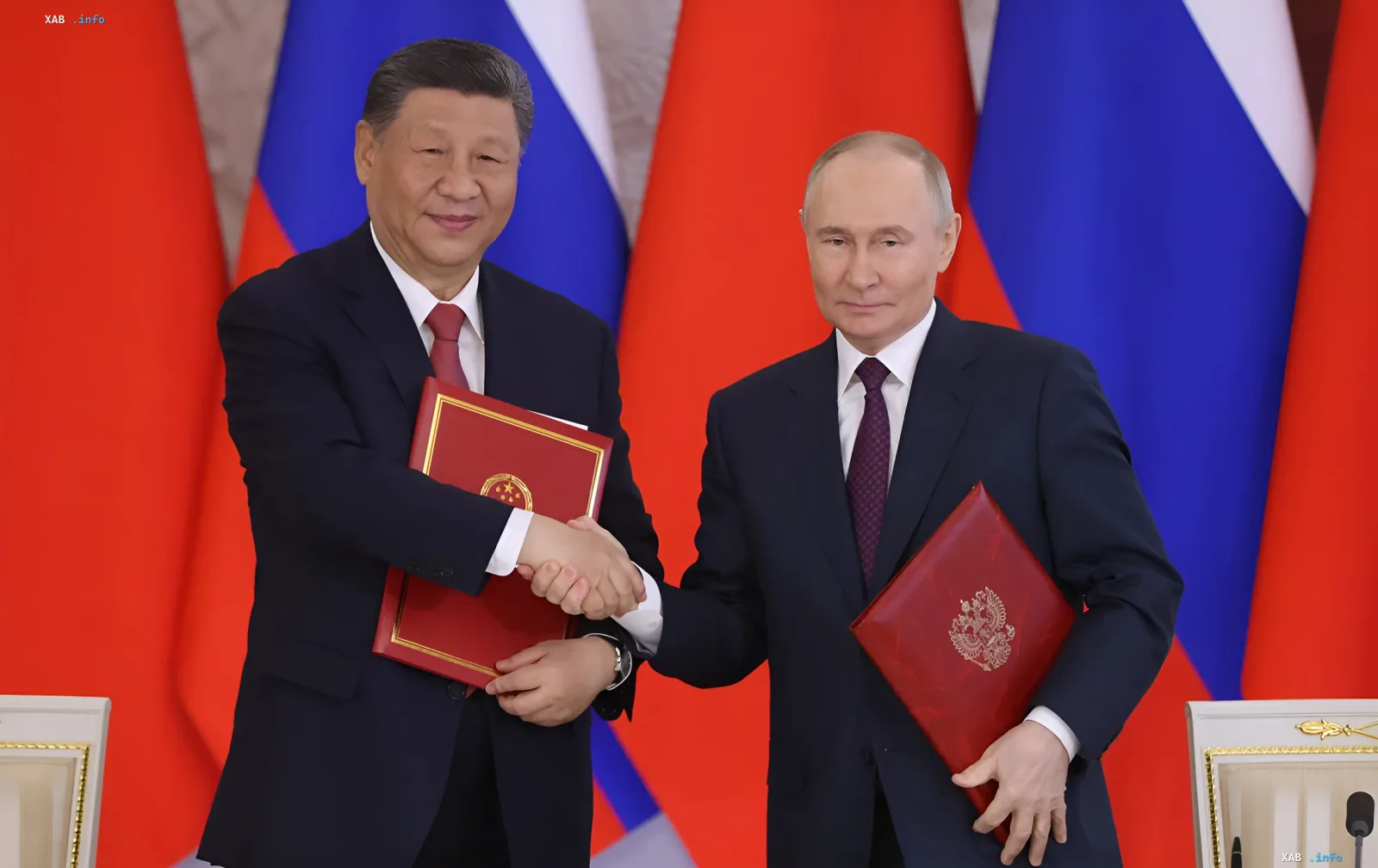 Си Цзиньпин и Владимир Путин на фоне флагов Китая и России подписывают документы о сотрудничестве, скрывающем поставки химикатов для дронов-камикадзе
