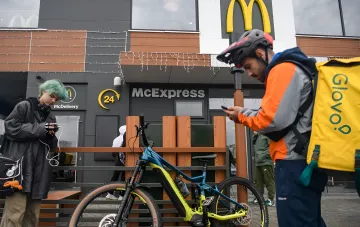 Курьеры Glovo и посетители у ресторана McDonald's с вывеской McDelivery в Украине