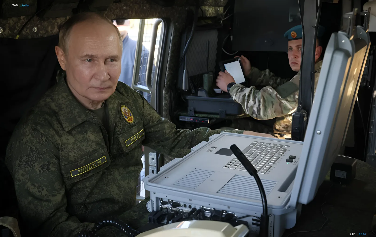 Wladimir Putin in Tarnung an einem militärischen Kommandogerät vor dem Hintergrund des Rekordverteidigungsbudgets Russlands