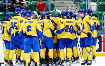 Spieler der ukrainischen Eishockey-Nationalmannschaft in gelb-blauen IIHF-Trikots versammeln sich auf dem Eis vor dem Top-Division-Weltmeisterschaft 2027
