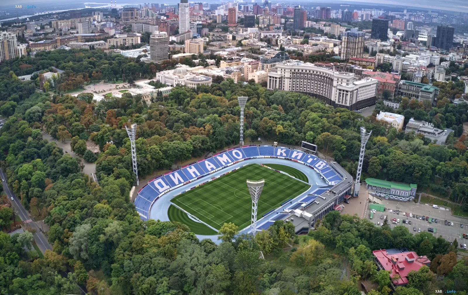 Leeres Dynamo-Stadion in Kiew mit blauen Tribünen und Clubnamen vor dem Stadtpark und der Skyline der Hauptstadt