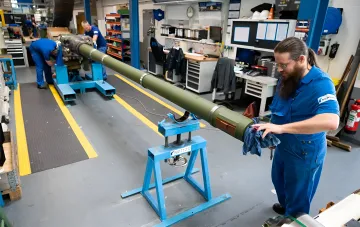 Працівник Rheinmetall у виробничому цеху оглядає елемент системи ППО на заводі, який Volkswagen передає під військове виробництво в Оснабрюку