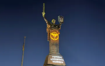 Ночной вид на памятник «Батькивщина-Мать» в Киеве с проекцией эмблемы Главного управления разведки на постаменте
