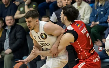 Battle for the ball in a Ukrainian Basketball Super League match: player in 'Kharkiv Falcons' uniform and opponent