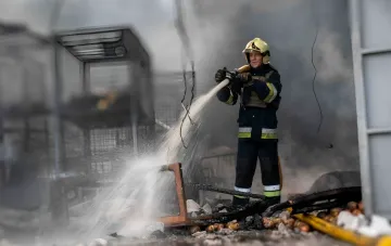 Feuerwehrmann löschte einen Brand auf dem beschädigten Markt „7. Kilometer“ bei Odessa nach einem russischen Angriff