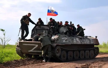 Российские военные на бронетранспортере с флагом РФ в зоне боевых действий