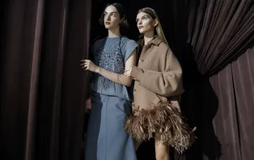 Модели в коллекциях Ukrainian Fashion Week SS27: серый свитер с блёстками и коричневый костюм с перьевым декором