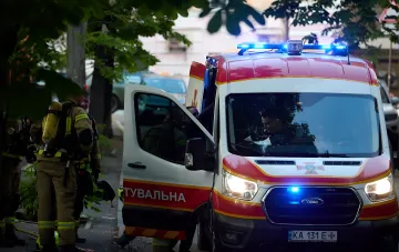 Пожарные и спасатели на месте попадания российского дрона в девятиэтажный дом в Киеве