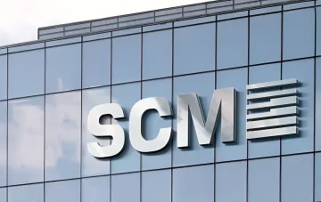 SCM logo on the glass facade of an office building — Rinat Akhmetov's company invested $4.3 billion in Ukraine