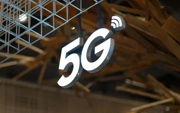 Светящийся знак 5G с символом беспроводной связи на фоне выставочного зала — пилотное тестирование сети пятого поколения в Одессе
