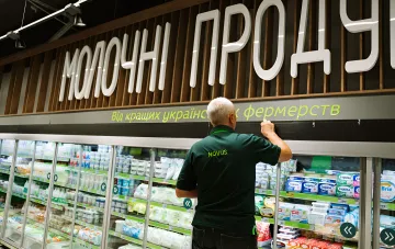 Сотрудник сети NOVUS в отделе молочных продуктов украинского супермаркета, где дорожают молоко и базовые продукты