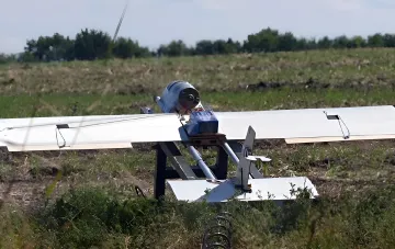 Дрон Grim LA-80 від GrimTech з довгими білими крилами на демонстраційній підставці в полі — український аналог російської «Молнії»