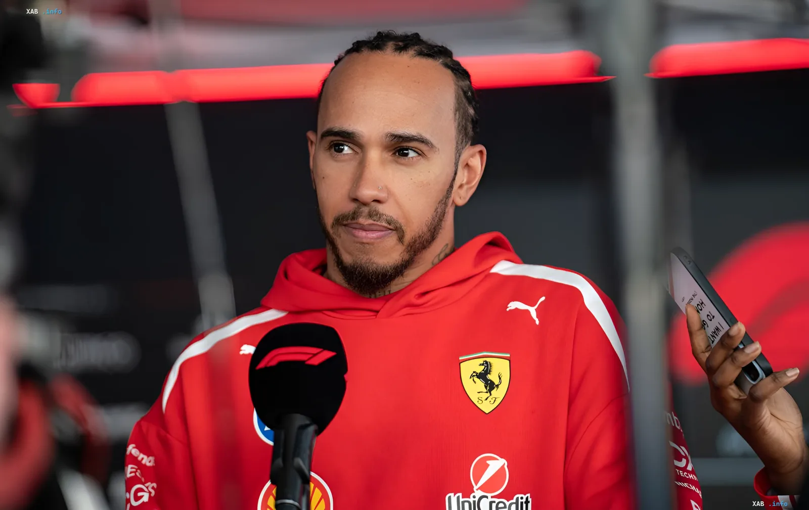 Lewis Hamilton in red Ferrari teamwear during a press interview after collision with Charles Leclerc at Monza