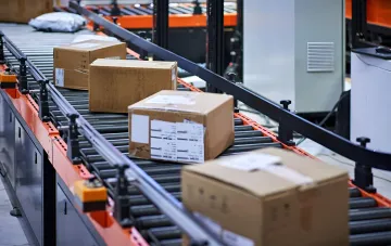 Картонні посилки з інтернет-магазинів на конвеєрі сортувального центру: контекст запровадження ПДВ на онлайн-замовлення до 150 євро